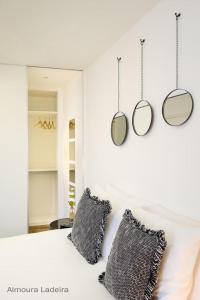 埃武拉Almoura Ladeira的卧室配有一张床铺,墙上挂有两面镜子