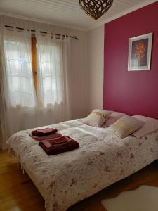 马雷讷Chambre Zen à la campagne的一间卧室配有一张大床和紫色墙壁