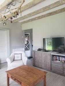 马雷讷Chambre Zen à la campagne的客厅配有电视和木制咖啡桌。
