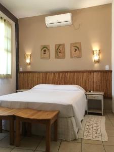 巴拉-沙希Pousada Aroeira的卧室配有白色大床和长凳