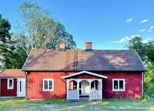 奥斯卡港Lilla Hule - på landet nära sjö的一间红色的房子,有白色的门和屋顶