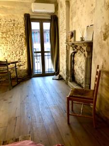 米兰Charming and Design Attic Loft Central Milan in coolest area Navigli Ticinese的客房设有壁炉、椅子和窗户。