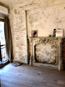 米兰Charming and Design Attic Loft Central Milan in coolest area Navigli Ticinese的客房设有带微波炉的石制壁炉。