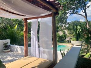 艾库玛尔Villa Morena Boutique Hotel Ecoliving的一个带白色天篷和游泳池的庭院