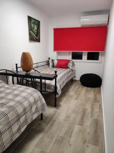 瓦伦西亚Lille en Provence的一间设有两张床和红色窗帘的房间