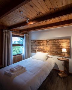 库拉考廷HOTEL VOLKANICO的卧室配有白色的床和木墙