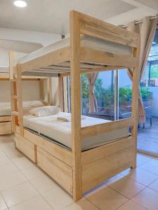 圣塔特蕾莎海滩El Gato Rojas Surf Hostel的配有窗户的客房内的一张木制双层床