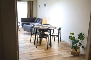 德哈恩Ruim, lichtrijk appartement met terras in centrum的客厅配有桌椅和沙发