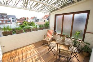 德哈恩Ruim, lichtrijk appartement met terras in centrum的阳台的天井配有桌椅