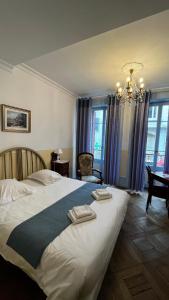 埃维昂莱班Hôtel Continental的一间卧室配有一张大床和两条毛巾