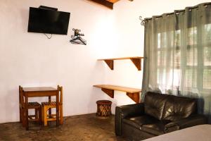 特科曼San Rafael的客厅配有沙发和墙上的电视