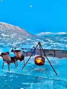 赫尔甘屯Large and luxurious family cabin in Myrkdalen的雪地里带壁炉和椅子的房间