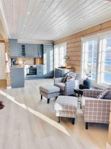 赫尔甘屯Large and luxurious family cabin in Myrkdalen的带沙发和椅子的客厅以及厨房。