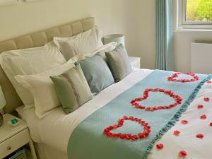 多尔金Ranmore Rise Retreat in the Surrey Hills的一张床上有两朵红玫瑰
