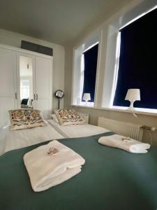 雷克雅未克Enjoy Reykjavík Yellow Door Apartment的一间卧室配有两张带毛巾的床