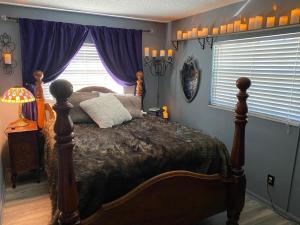 坦帕Phantom History House Castle Room的一间卧室配有一张床和一个带紫色窗帘的窗户
