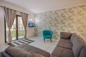 格兰高伯Le Palmiste lovely 2-bedroom duplex with pool的带沙发和蓝椅的客厅