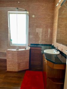 埃斯托利尔Estoril dream的一间带水槽和浴缸的浴室,并设有一个窗口