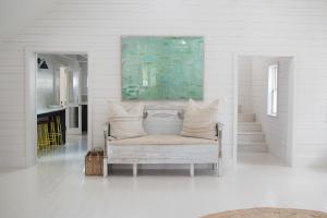 哈勃岛Conch Shell Harbour Island home的白色的房间,墙上挂着一幅画