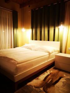 巴德瓦尔特斯多夫Aparthotel "Goldener Hahn Apartments"的一间卧室配有一张带白色床单的大床