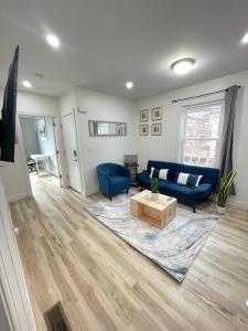 泽西市Modern Luxury Apartment near NYC的客厅配有蓝色的沙发和桌子
