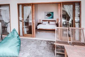 吉利特拉旺安Kelapa Kecil的一间卧室设有床和滑动玻璃门