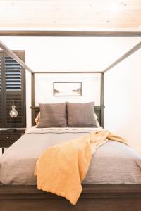 彭萨科拉Haven House的一间卧室配有一张带橙色毯子的床