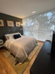 基多Modern Apartment in the Heart of Quito的一间卧室设有一张大床和一个大窗户