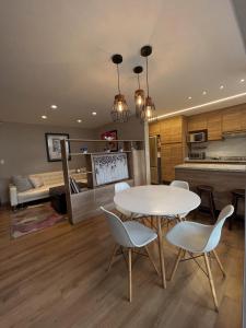 基多Modern Apartment in the Heart of Quito的厨房以及带桌椅的起居室。