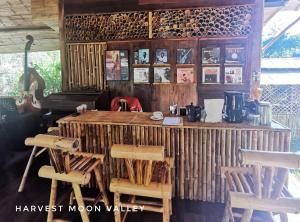 Ban Pang LuangHarvest Moon Valley的客房设有带椅子和桌子的木制柜台。