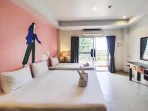 芭堤雅市中心Bella Villa Pattaya 3rd Road的一间设有两张床的房间,墙上挂着一幅女人的画