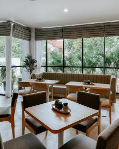 雅加达CASA CALMA HOTEL的餐厅设有桌椅和大窗户。