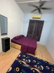 马六甲DakNan Homestay Duyong的一间卧室配有紫色的床和吊扇