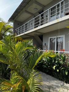 西哈努克Ginger Sihanoukville的前面有棕榈树的房子
