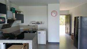 高兰Aranya Resort Koh Lanta的厨房配有冰箱和墙上的时钟