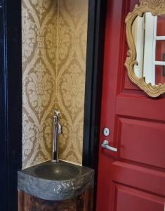 皮耶克赛迈基Wanha Neuvola Guesthouse & Apartment的红色门旁带水槽的浴室