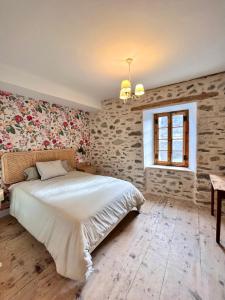 萨拉尔杜Hostel Baqueira - Refugi Rosta - PyrenMuseu的卧室配有白色大床和砖墙