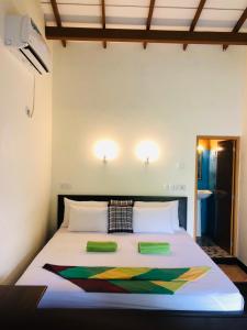 锡吉里亚Sigiri Liya Rest的一间卧室配有一张带两个绿色枕头的床