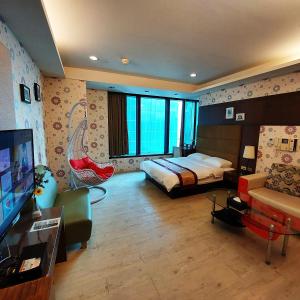 高雄布拉格旅宿(85 大楼)的一间卧室配有一张床,并在一间客房内配有电视。