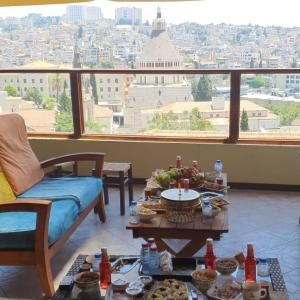 拿撒勒Seedi Yousef Hostel & Cafe的一间带桌子的客厅,享有城市美景