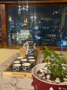 拿撒勒Seedi Yousef Hostel & Cafe的茶杯和桌子上的花瓶