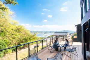 南淡路市Awaji-shima C-Side Dual View - Vacation STAY 88182v的三人坐在阳台上的桌子上,欣赏海景