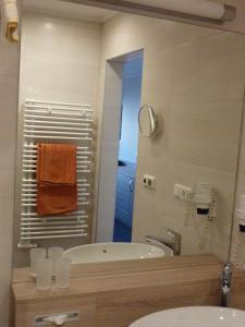 措布伦Glätzle`s Ferienhaus的带浴缸、水槽和镜子的浴室