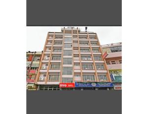 坎普尔Hotel Kanha Classic, Kanpur的一座高大的建筑,旁边有一个标志