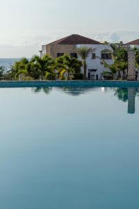 蒙巴萨Sultan Palace Beach Retreat Mombasa的享有带房屋的游泳池和大海的景致