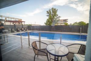 艾福雷诺德Hotel Ana Eforie的游泳池旁带桌椅的阳台