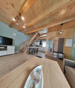卢巴夫卡Leśna Ostoja的大型客厅设有木制天花板和楼梯。