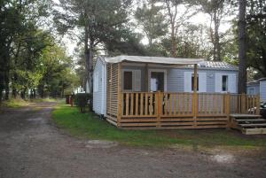 La Boissière-de-MontaiguMobil Home camping 3*** piscine chauffée的小屋为白色,设有木栅栏