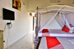 本托塔Esprit Bentota的一间卧室配有一张带红色枕头的天蓬床