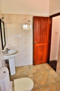 本托塔Esprit Bentota的一间带水槽和卫生间的浴室以及一扇木门。